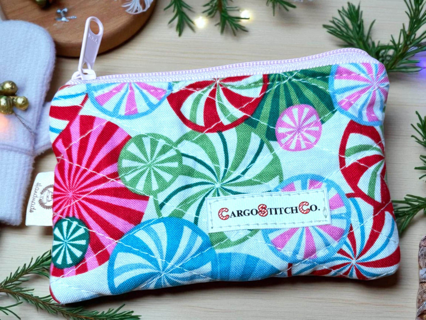 Handmade quilted pouch 5×3 in bright red, green and blue peppermint swirl design, pink zipper, no pocket — holiday coin purse from Cargo Stitch Co.