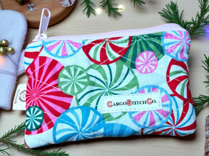 Handmade quilted pouch 5×3 in bright red, green and blue peppermint swirl design, pink zipper, no pocket — holiday coin purse from Cargo Stitch Co.